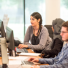 Three people working alongside each other at the desks