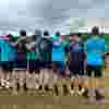 Image shows people at a start line linking arms. They are wearing alternate dark and light blue t-shirts. On th reverse is the Fight for Sight logo and our vision to Save Sight. Change Lives. 