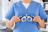 An optometrist holding glasses used in a refraction test.