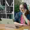 A woman at her laptop, taking a phone call