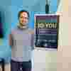 A headshot of Olly Minton standing in front of a wall at one of our shops