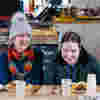 A woman and young girl sharing a laugh over lunch on a farm visit organised for young people with vision impairment. 