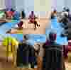 People sat casually around a table listening to a woman leading the workshop