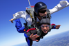 Photo of a man and a woman tandem skydiving