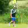 A man on the golf course, carrying a flag