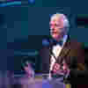 Sir John Major speaking at See my Skills gala 2022 he's standing behind a podium mid-speech wearing a formal suit with a bowtie