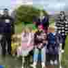 Members of the Didcot Green Walks Social Group sit together on a bench outdoors. 